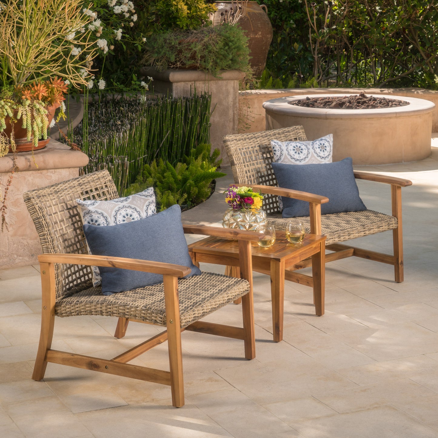 Wicker patio chairs with blue and patterned cushions on a tiled patio