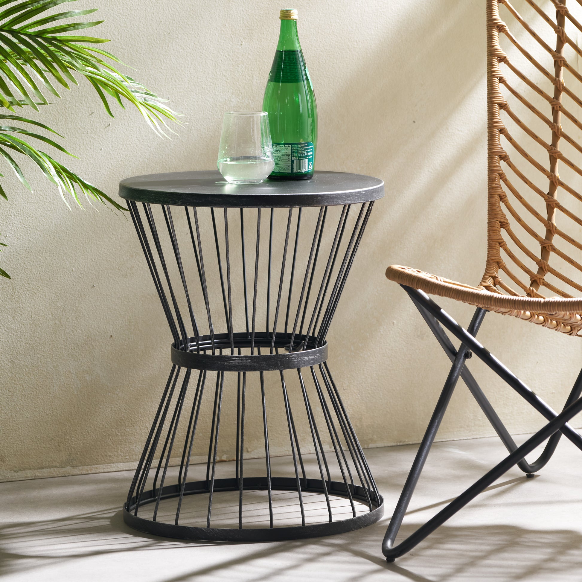Black metal side table with modern wire cage design and round top perfect for patios