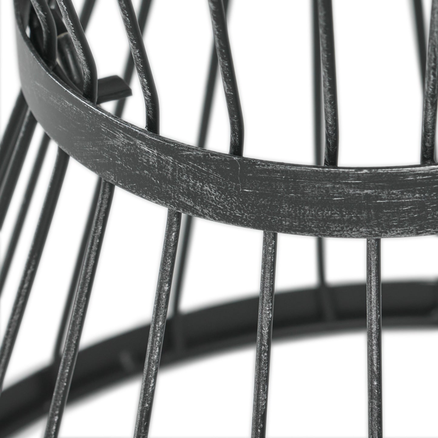 Closeup of distressed black metal basket frame with vertical bars and circular support