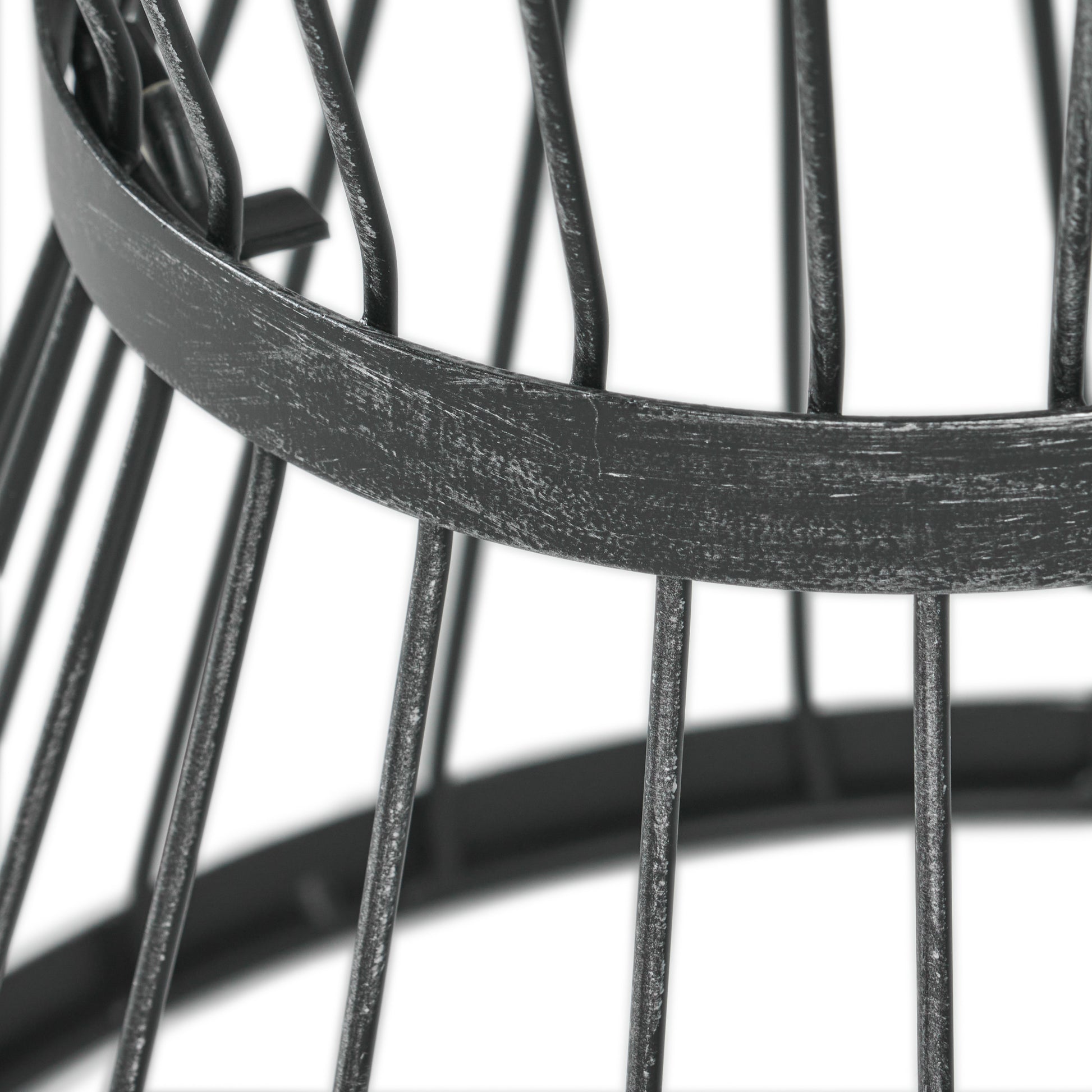 Closeup of distressed black metal basket frame with vertical bars and circular support
