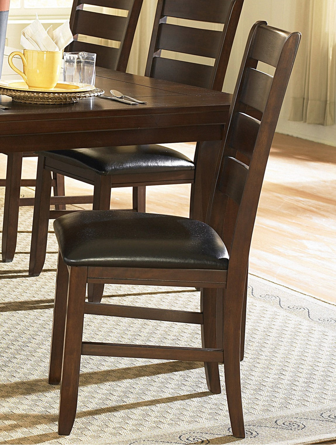 Dark wood dining chair with black faux leather seat and slatted back