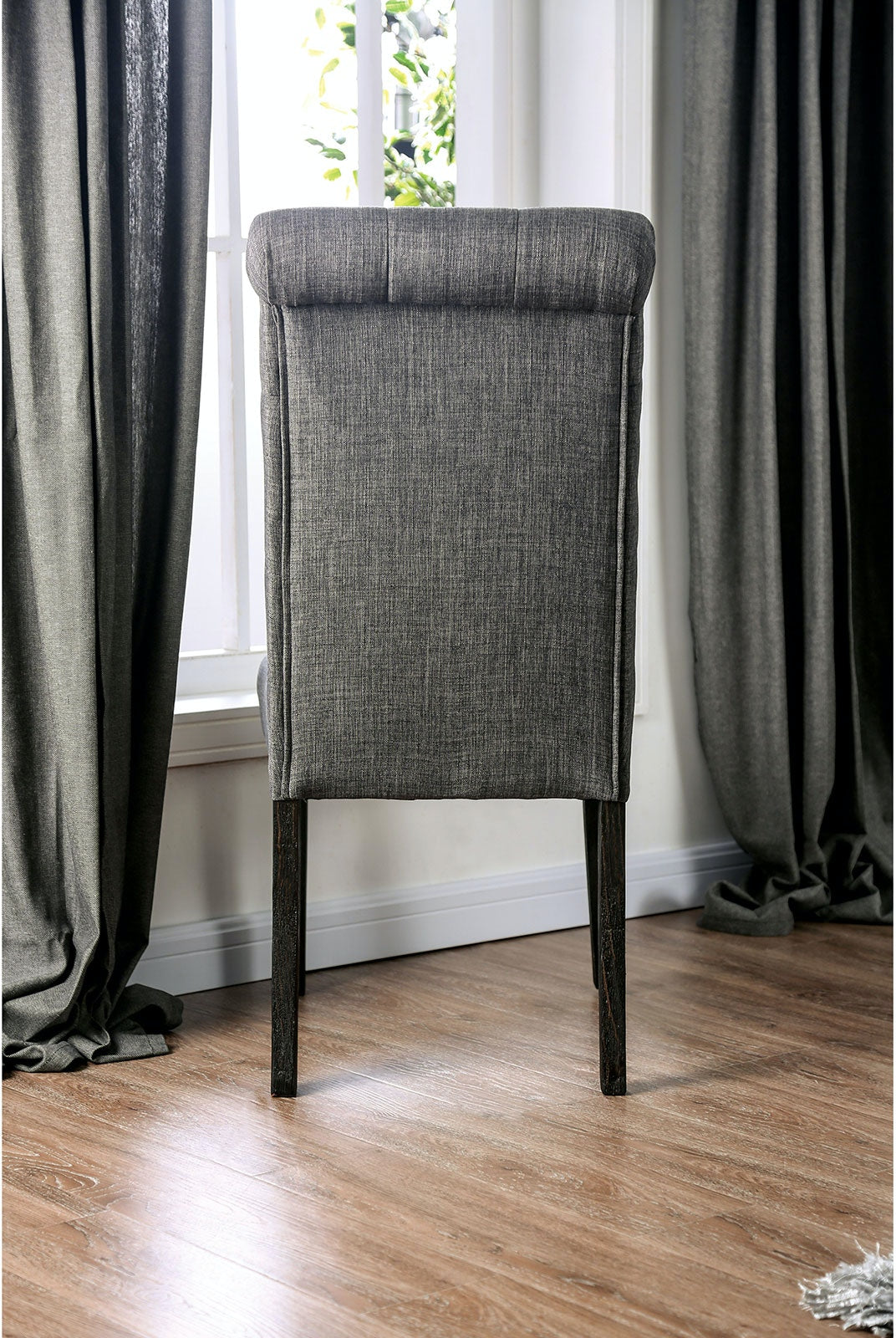 Upholstered dining chair with button tufting on a dark wood frame