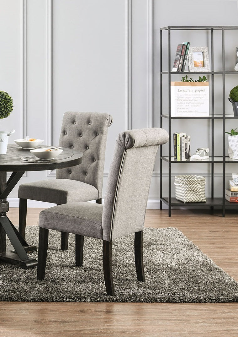 Tufted grey fabric dining chair with dark wood legs and a rolled back