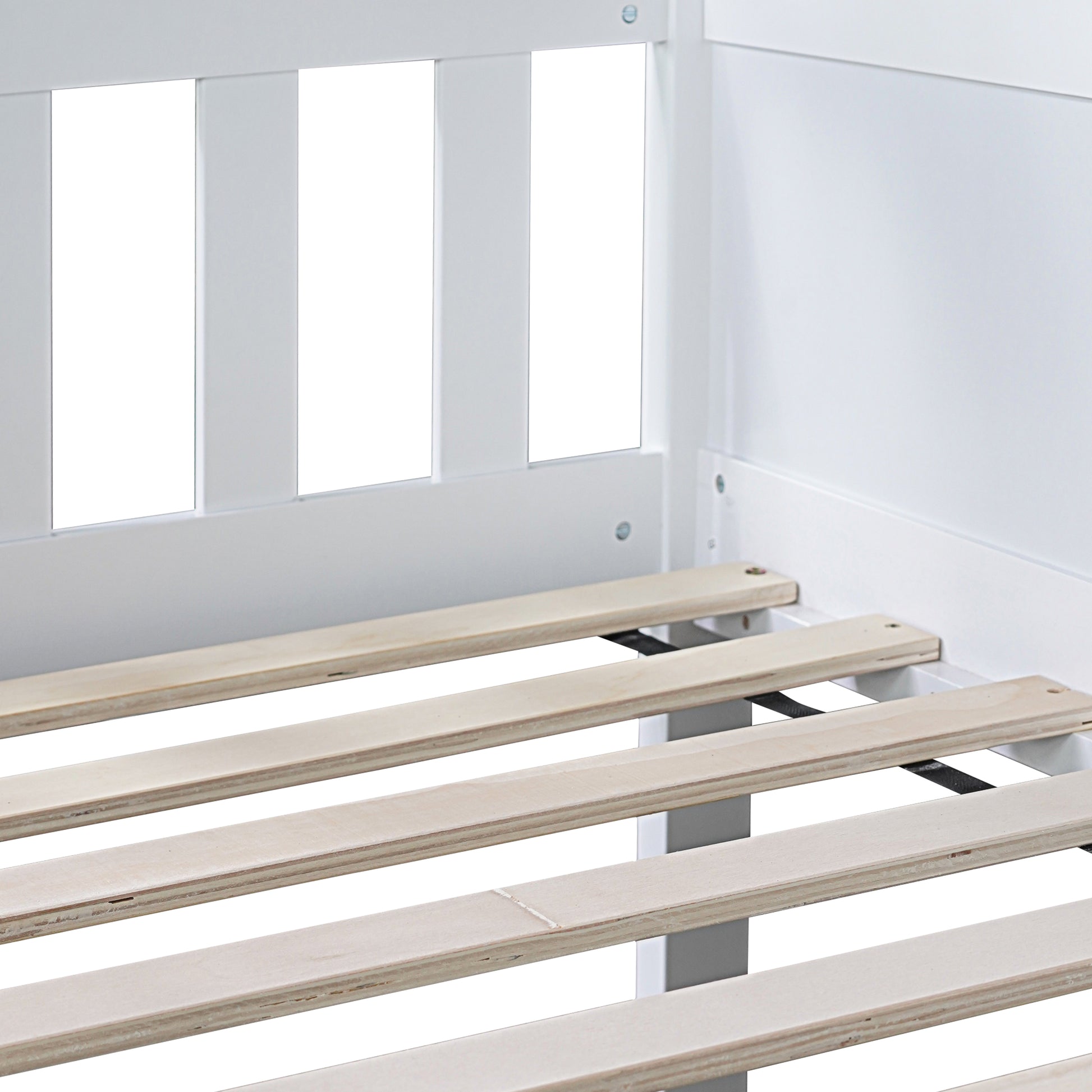 Closeup of white wooden bed frame with natural pine slats