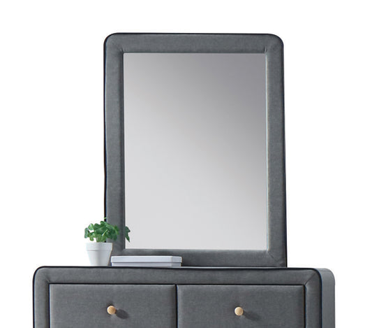 Upholstered gray vanity with mirror and minimalist design featuring two drawers with gold knobs