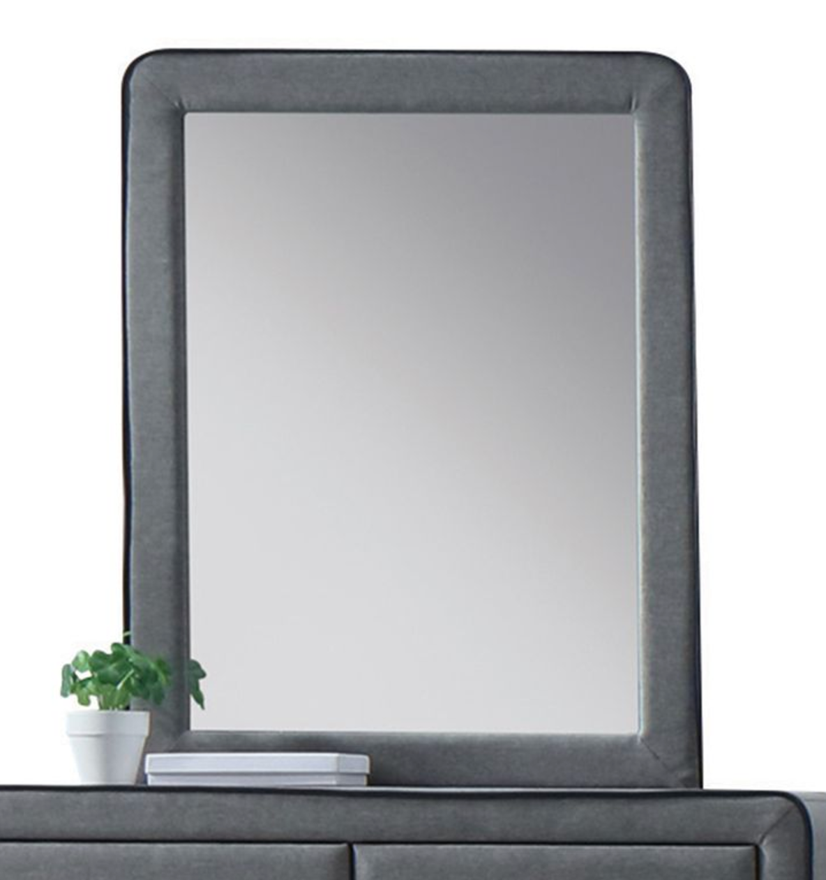 Dark gray upholstered mirror with rounded corners on a dresser