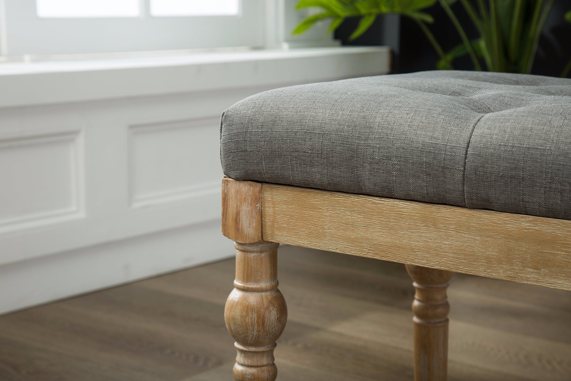 Tufted grey upholstered bench with distressed wood legs