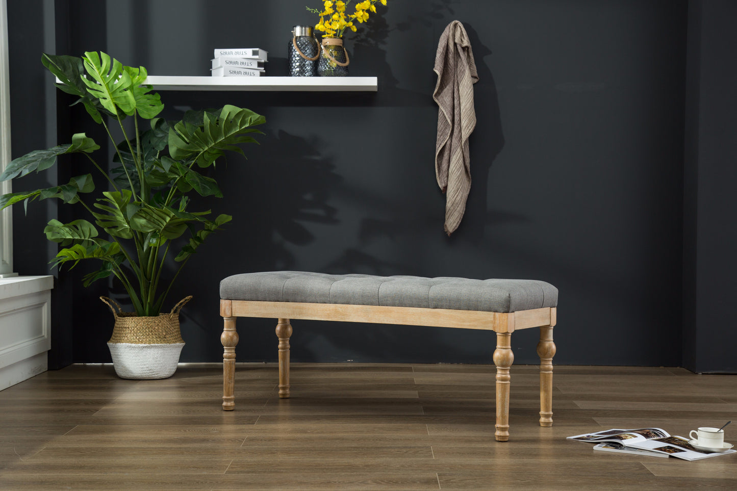 Tufted gray upholstered bench with light wood turned legs