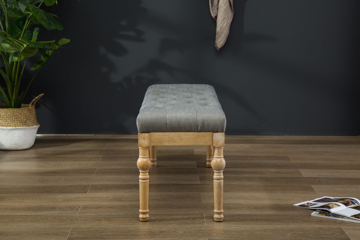 Tufted grey linen ottoman with carved wooden legs