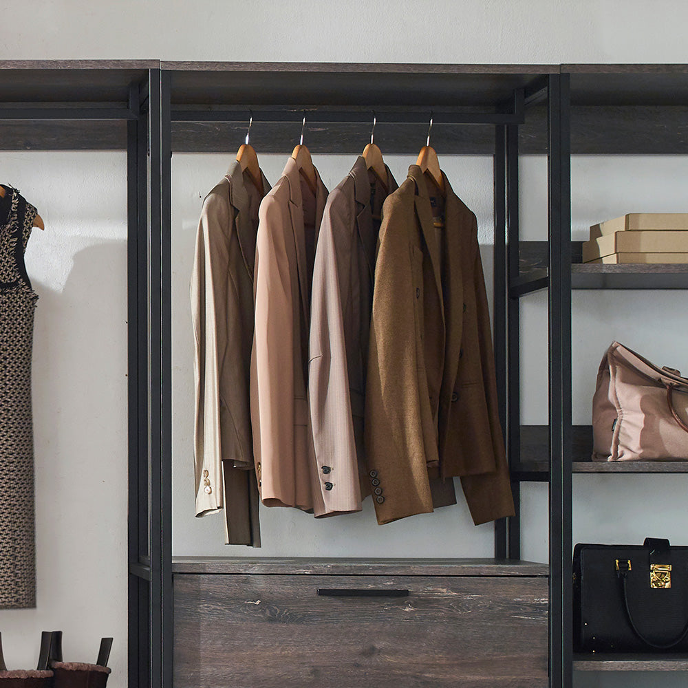 Four mens blazers in neutral tones hanging on a rack