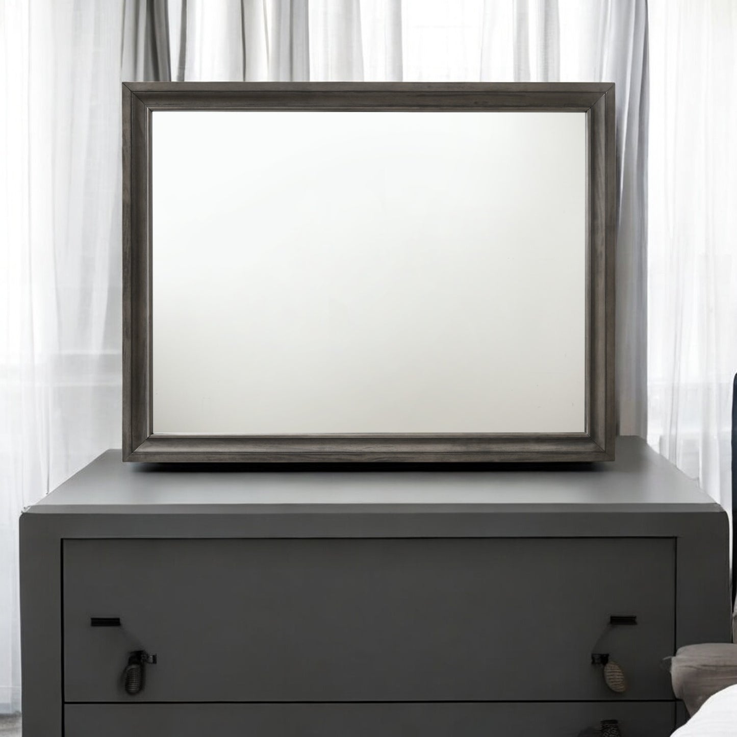 Gray wood frame mirror on dark gray dresser