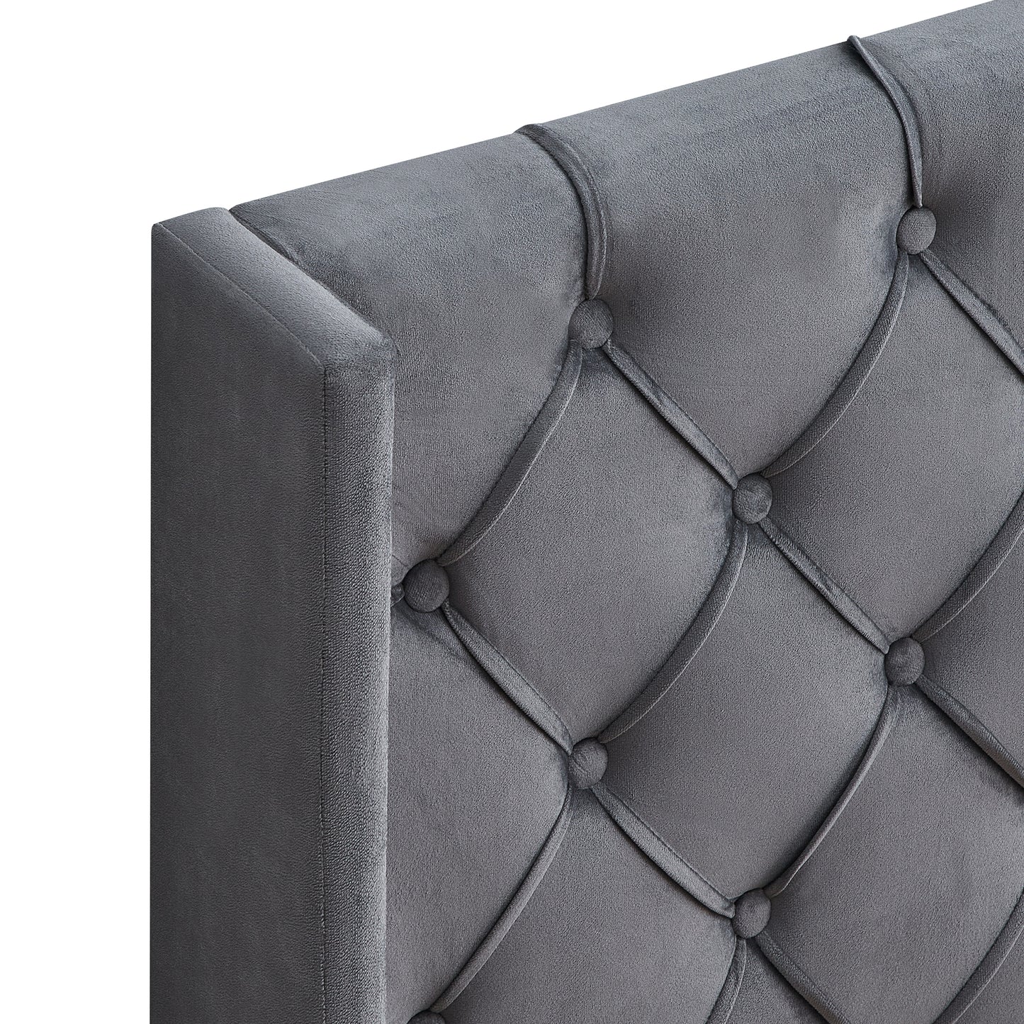 Closeup of a grey velvet tufted headboard with diamondshaped stitching and button accents