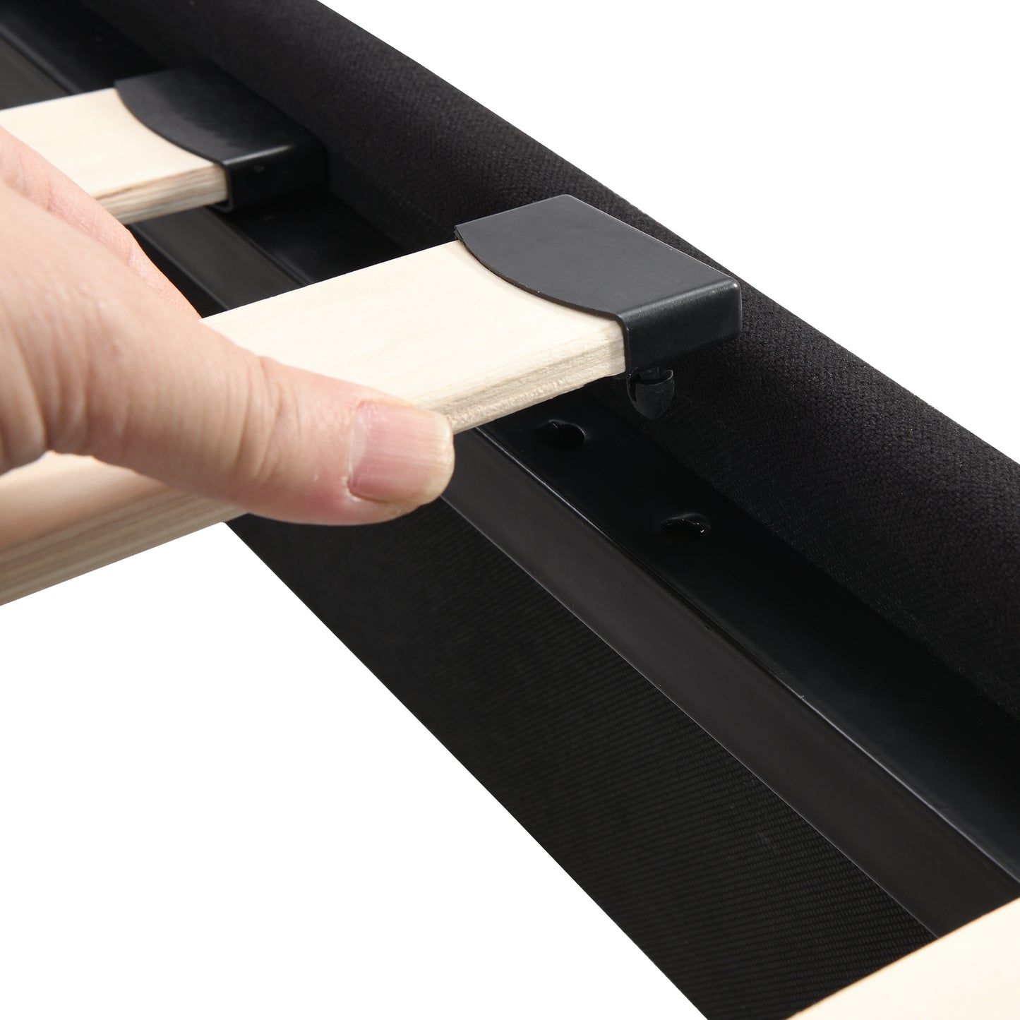 Closeup of hand inserting wooden slat into black bed frame bracket