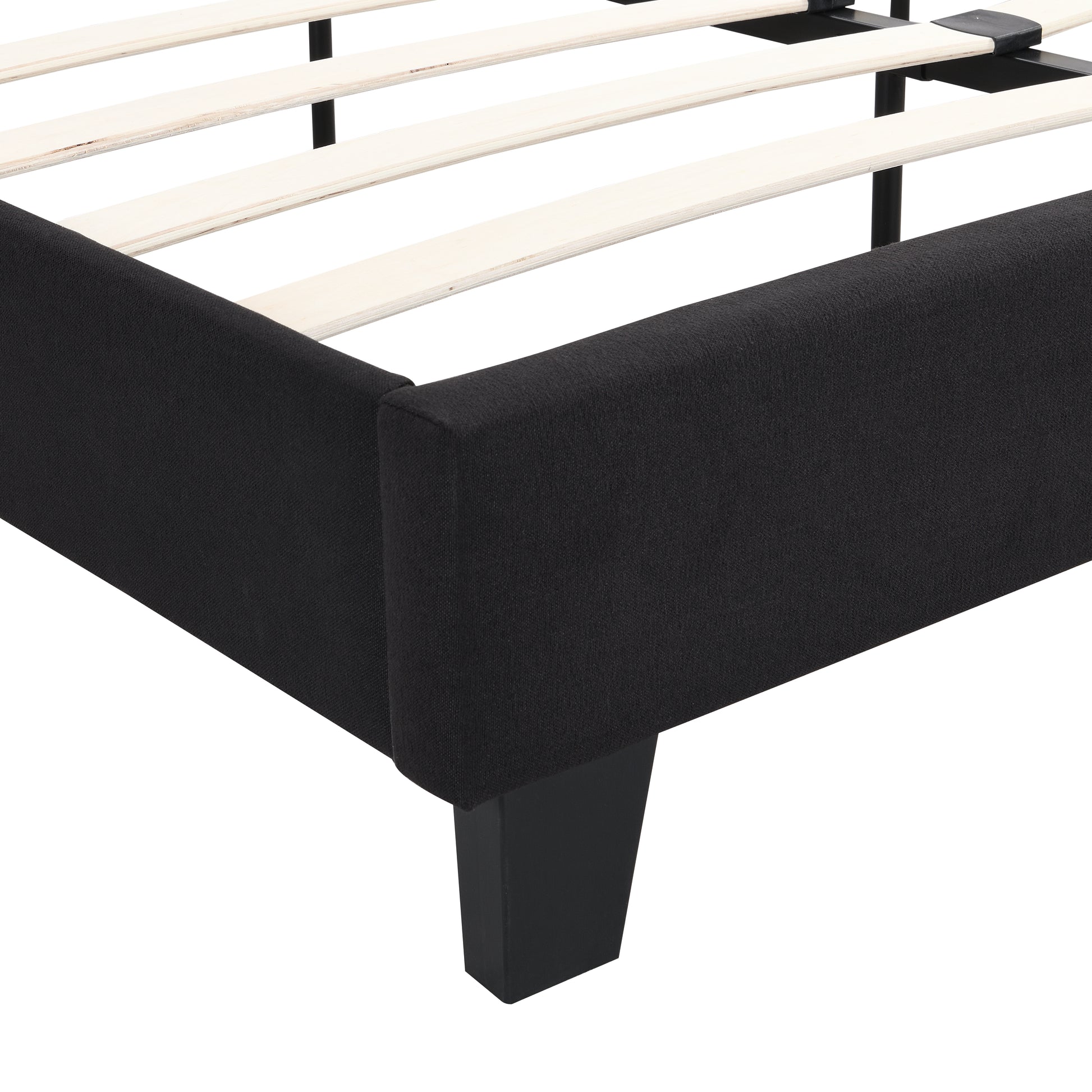Closeup of black upholstered bed frame with wooden slats