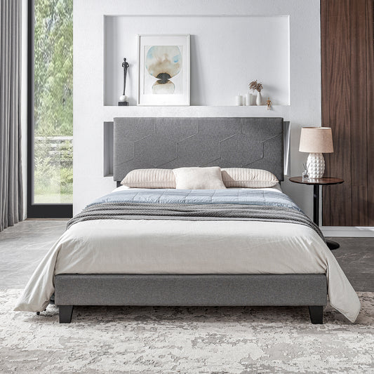Grey upholstered bed frame with geometric headboard and striped duvet