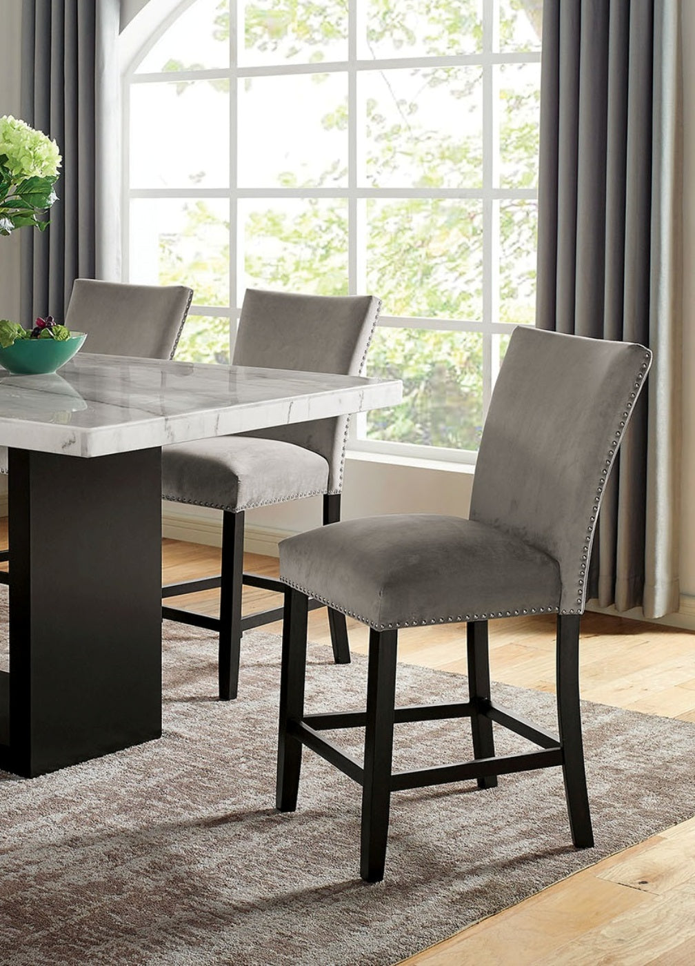 Gray velvet bar stool with nailhead trim and dark wood legs