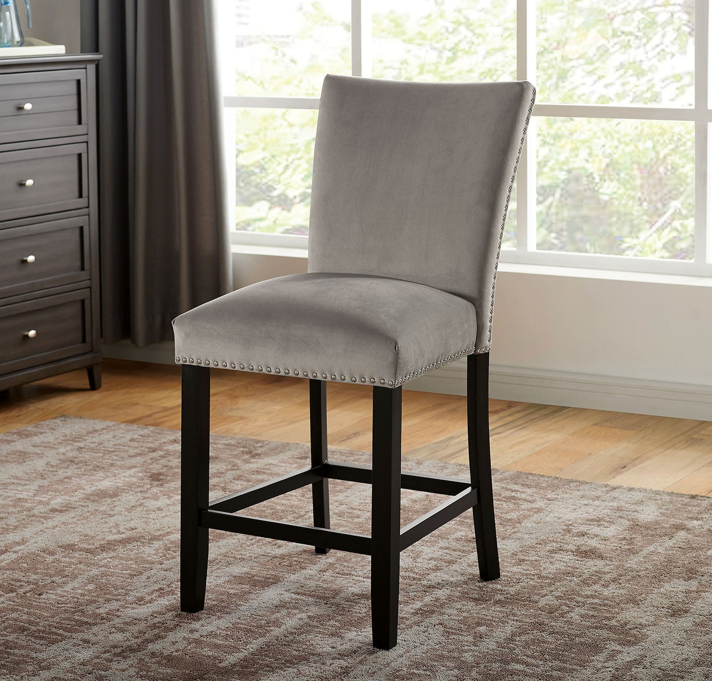 Grey velvet bar stool with silver nailhead trim and dark wood legs