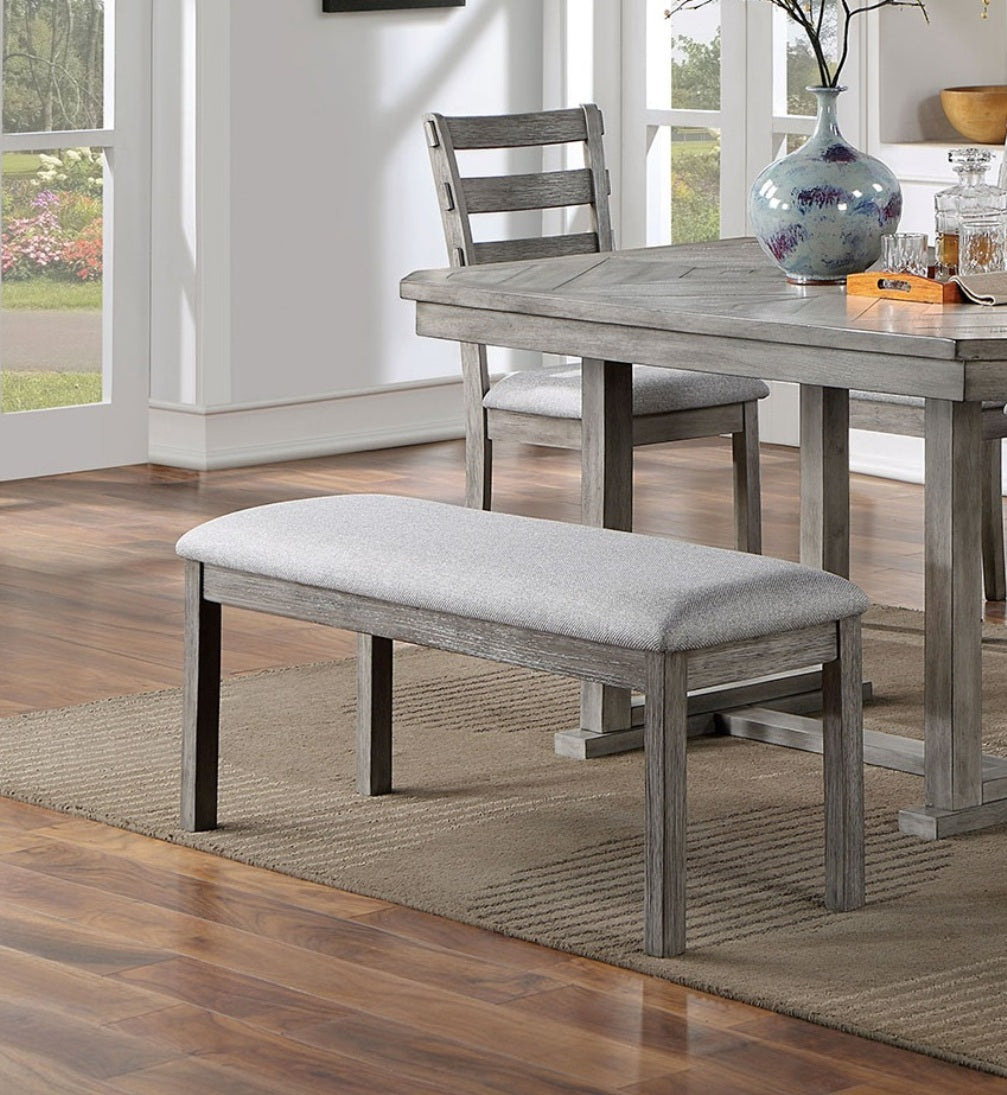 Grey upholstered dining bench with a rustic wood frame