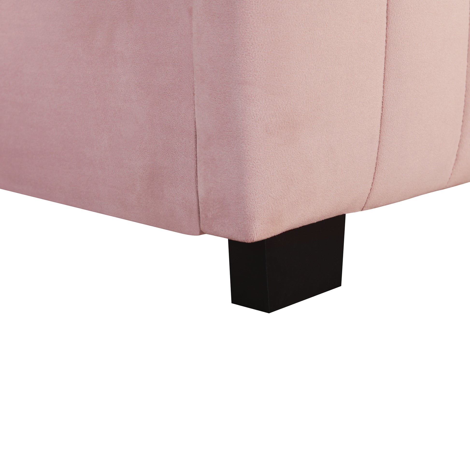 Closeup of plush pink velvet sofa fabric detail and black wooden leg