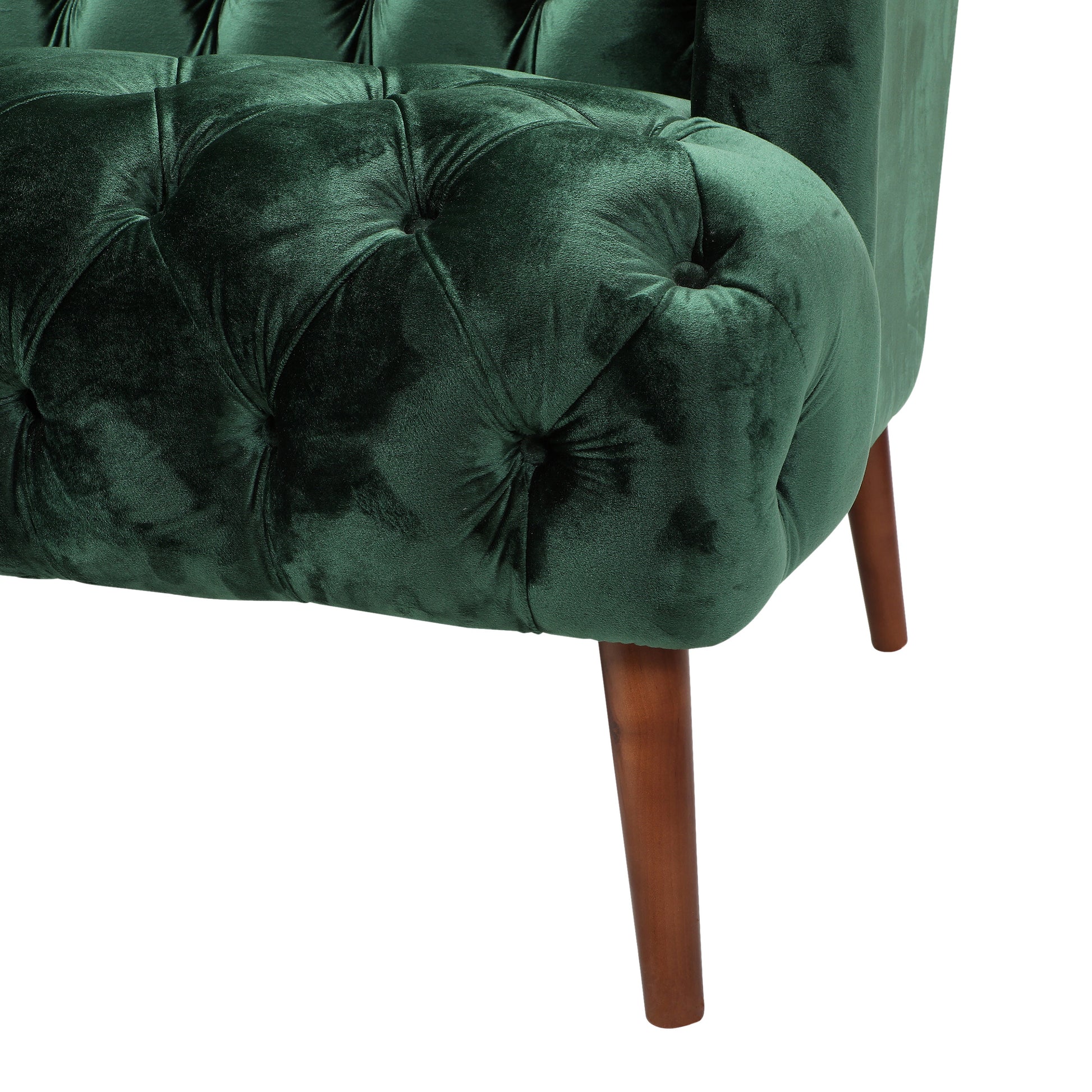 Deep green velvet armchair with tufted detailing and tapered wooden legs