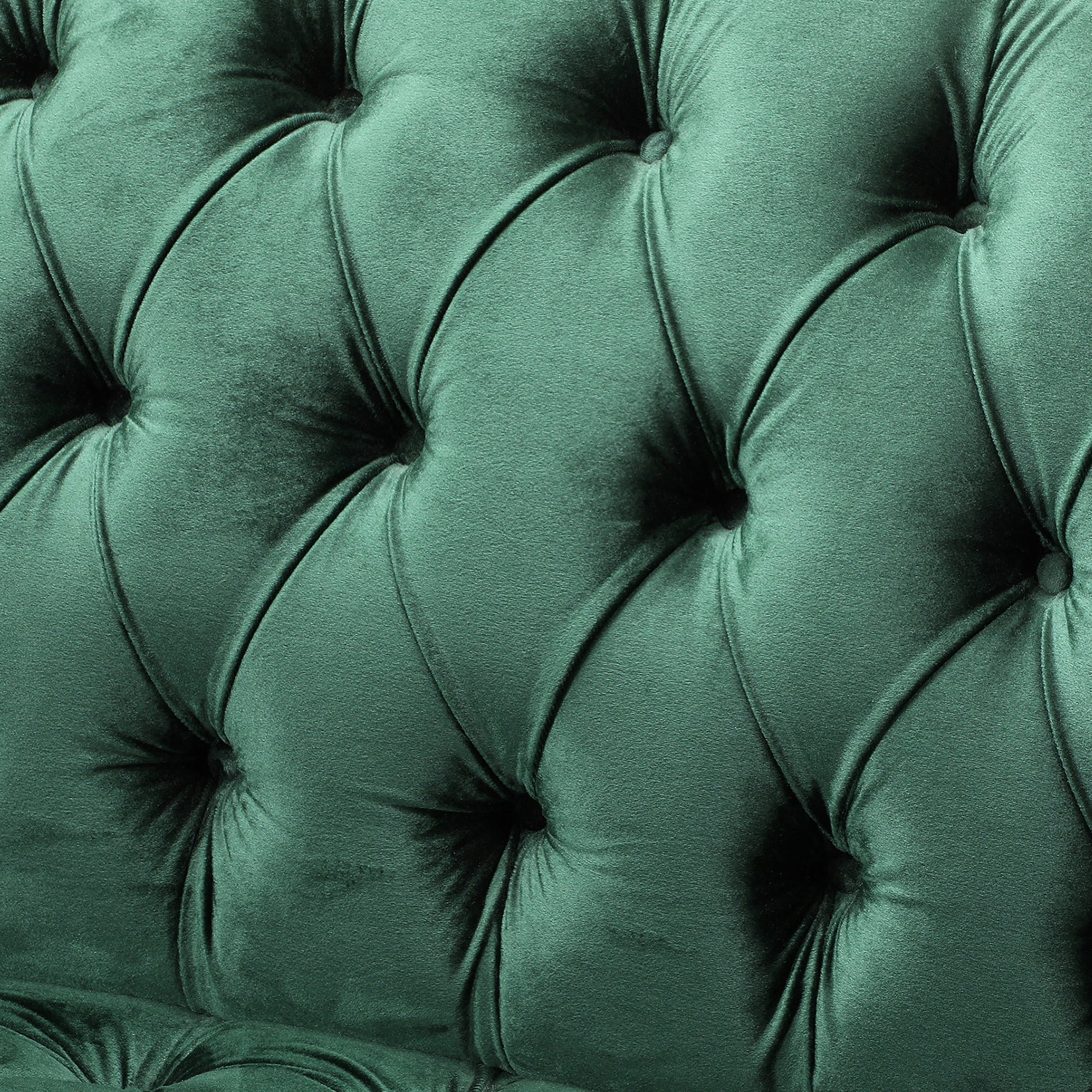 Closeup of deep emerald green velvet tufted fabric upholstery for a luxurious sofa