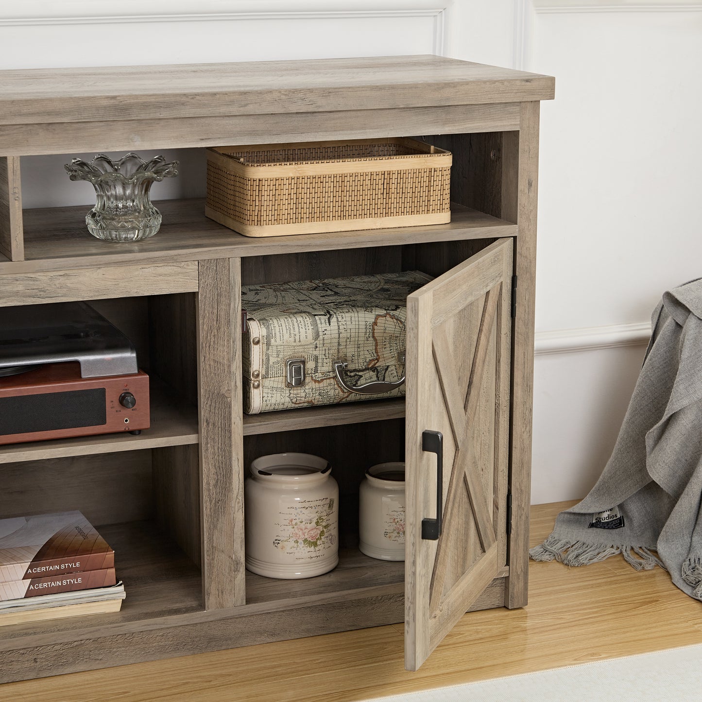 Rustic wood TV stand with barn door featuring storage shelves and decorative elements
