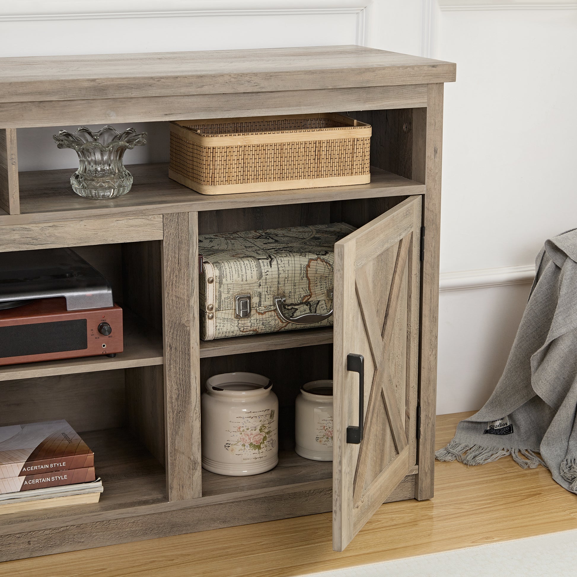 Rustic wood TV stand with barn door featuring storage shelves and decorative elements