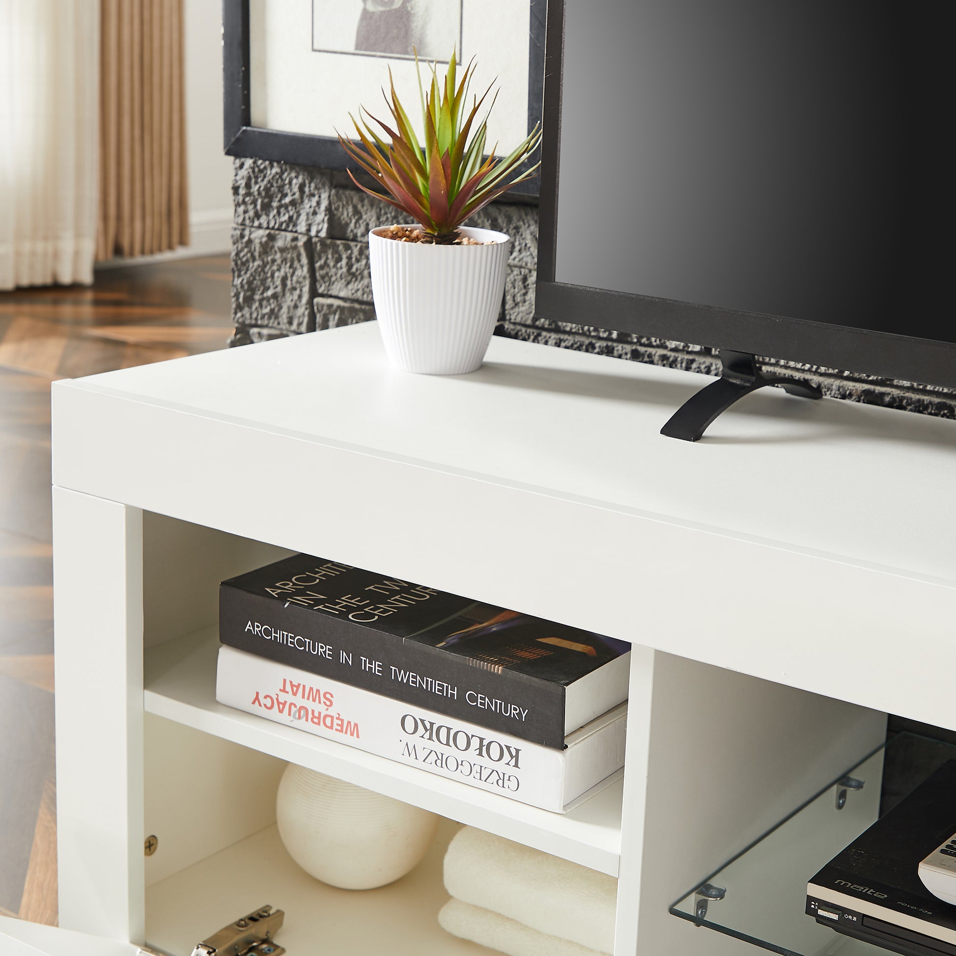 White modern media console with open shelves holding books and decor