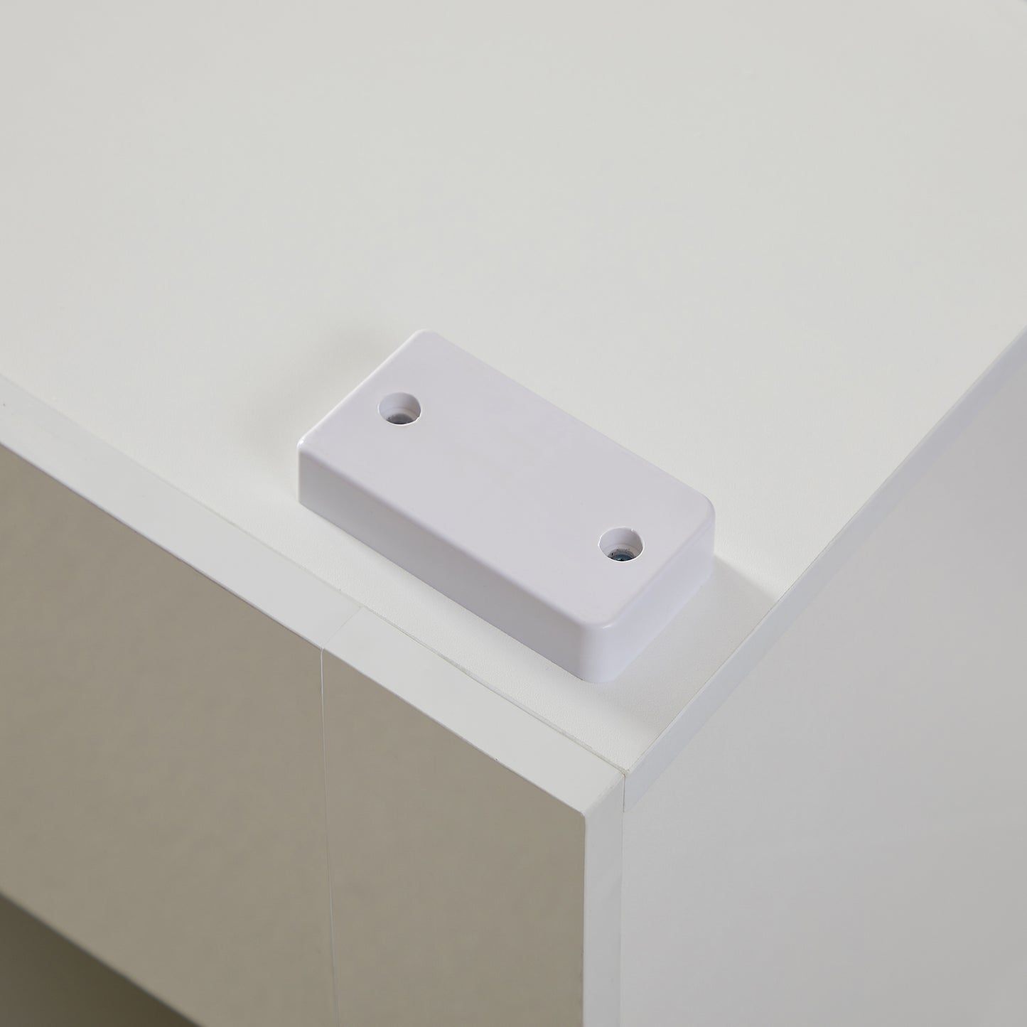 White plastic mounting bracket with two screw holes for securing items
