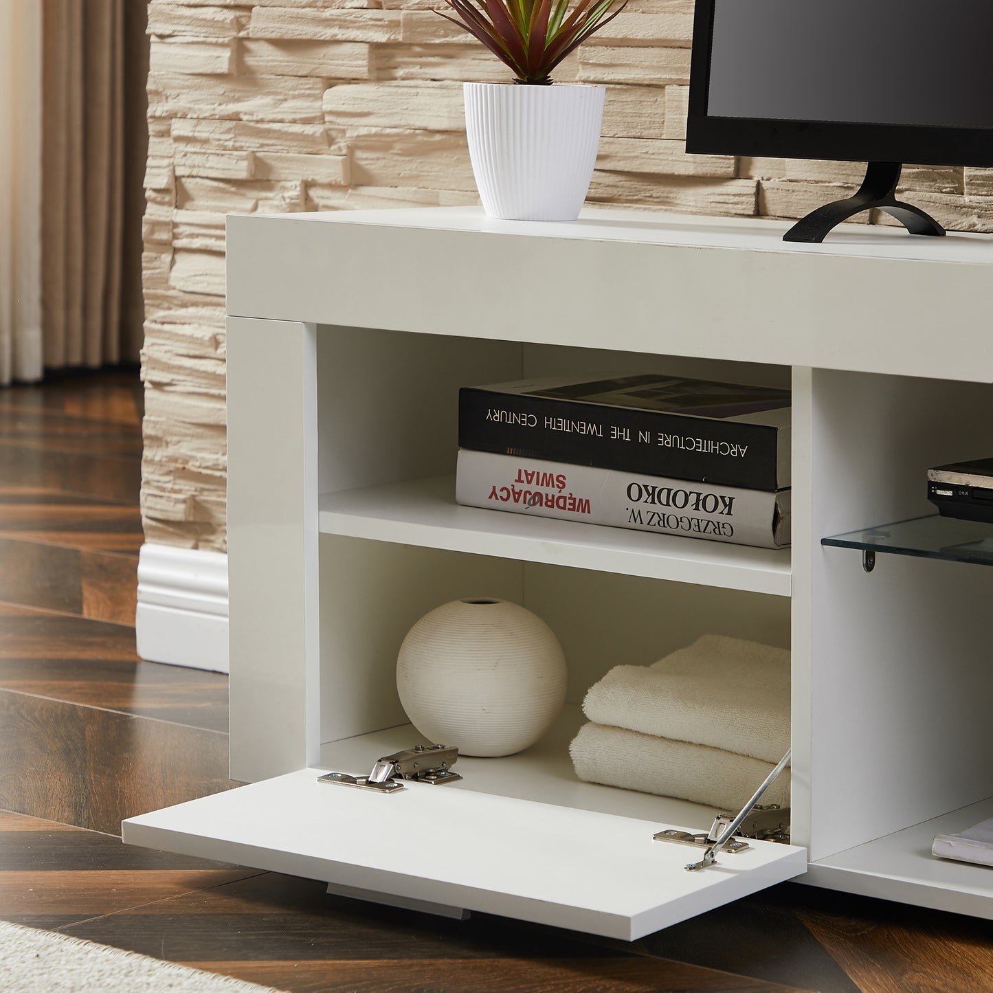 Modern white entertainment center with open shelving and a dropdown cabinet