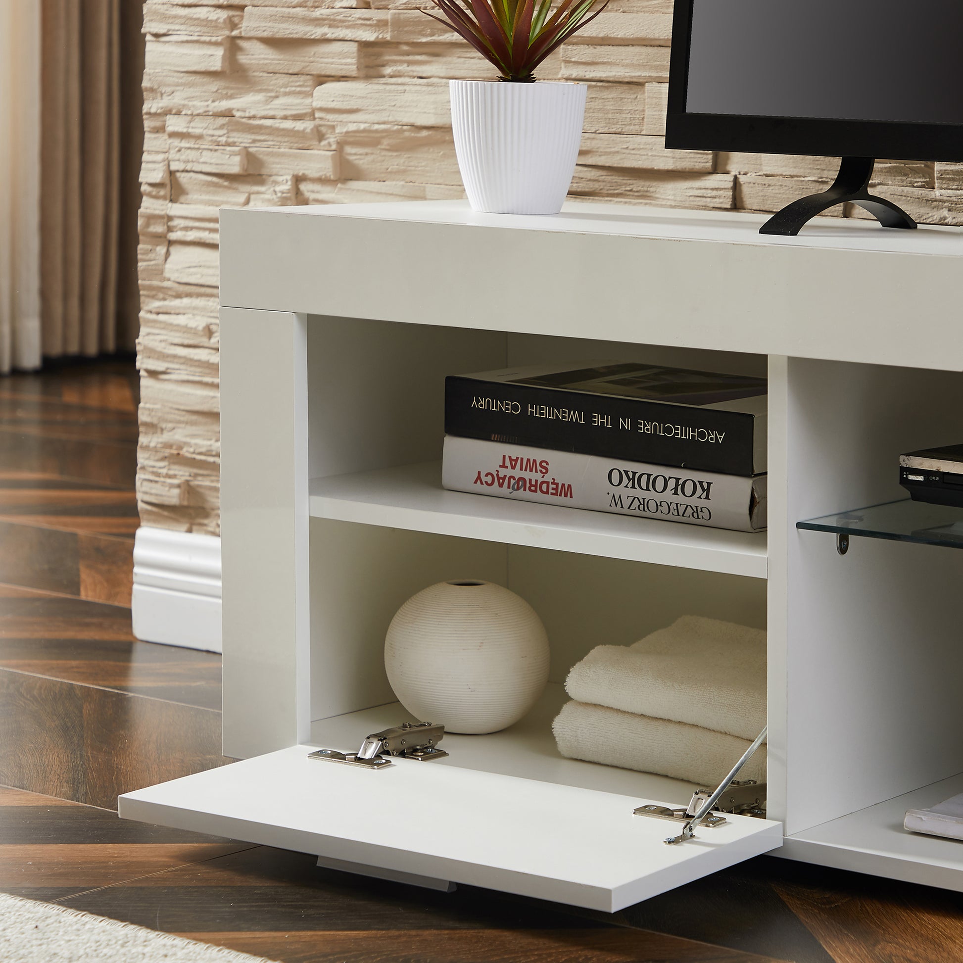 Modern white entertainment center with open shelving and a dropdown cabinet