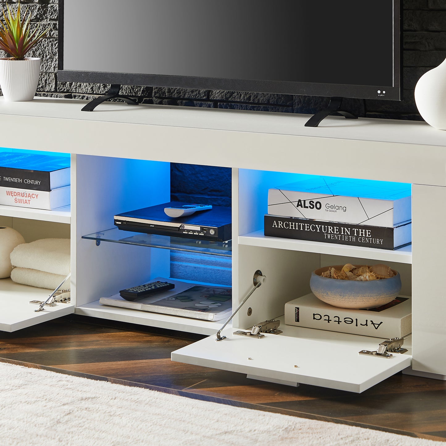 Modern white TV stand with blue LED lights featuring shelves and cabinets for media storage
