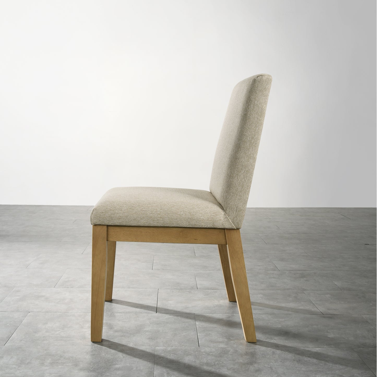 Side view of a beige textured upholstered dining chair with light oak wood legs