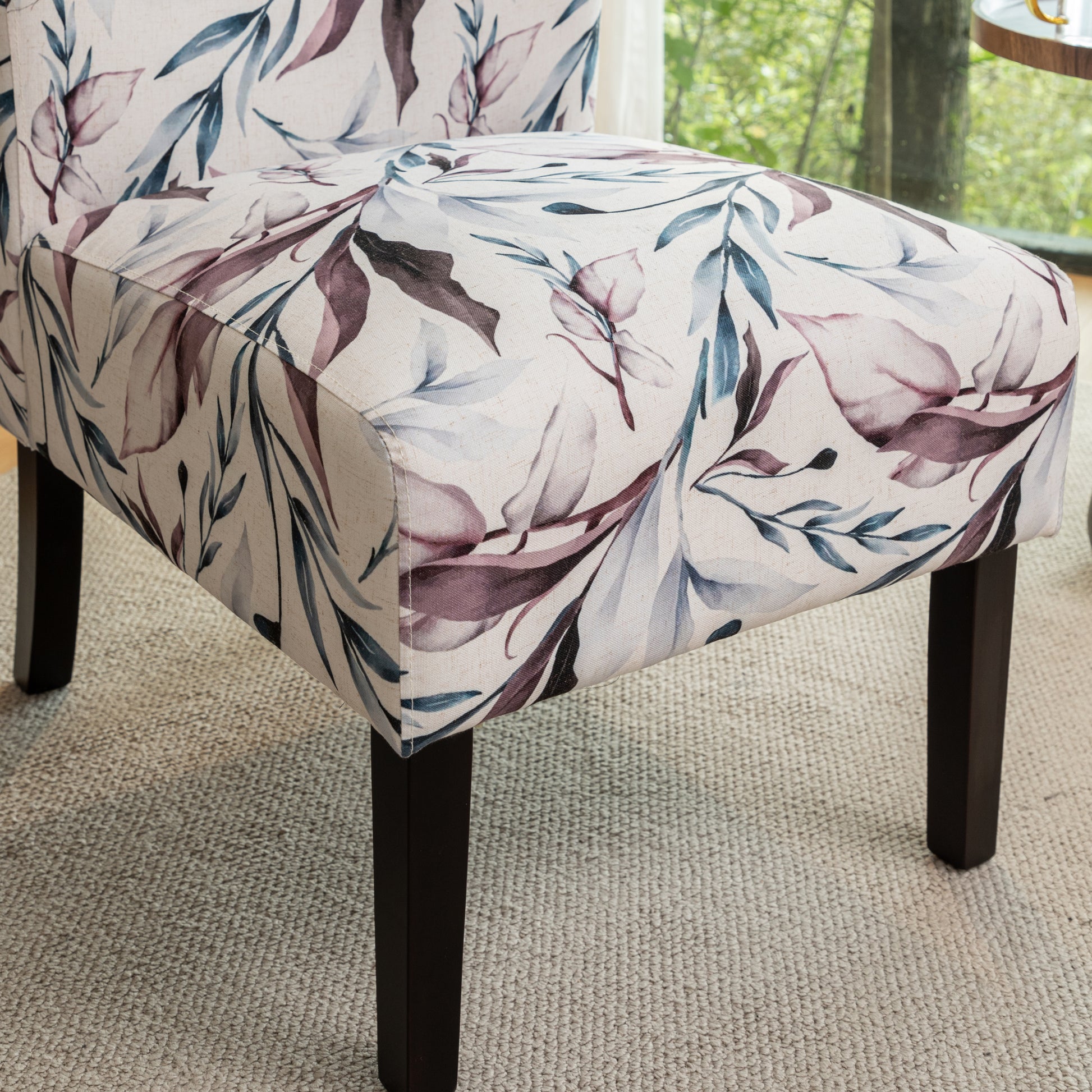 Beige accent chair with a floral watercolor pattern in plum and teal hues