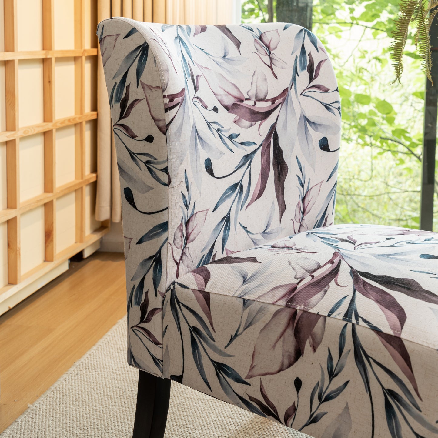 Upholstered armchair with a delicate floral leaf pattern in blues and purples on a cream background