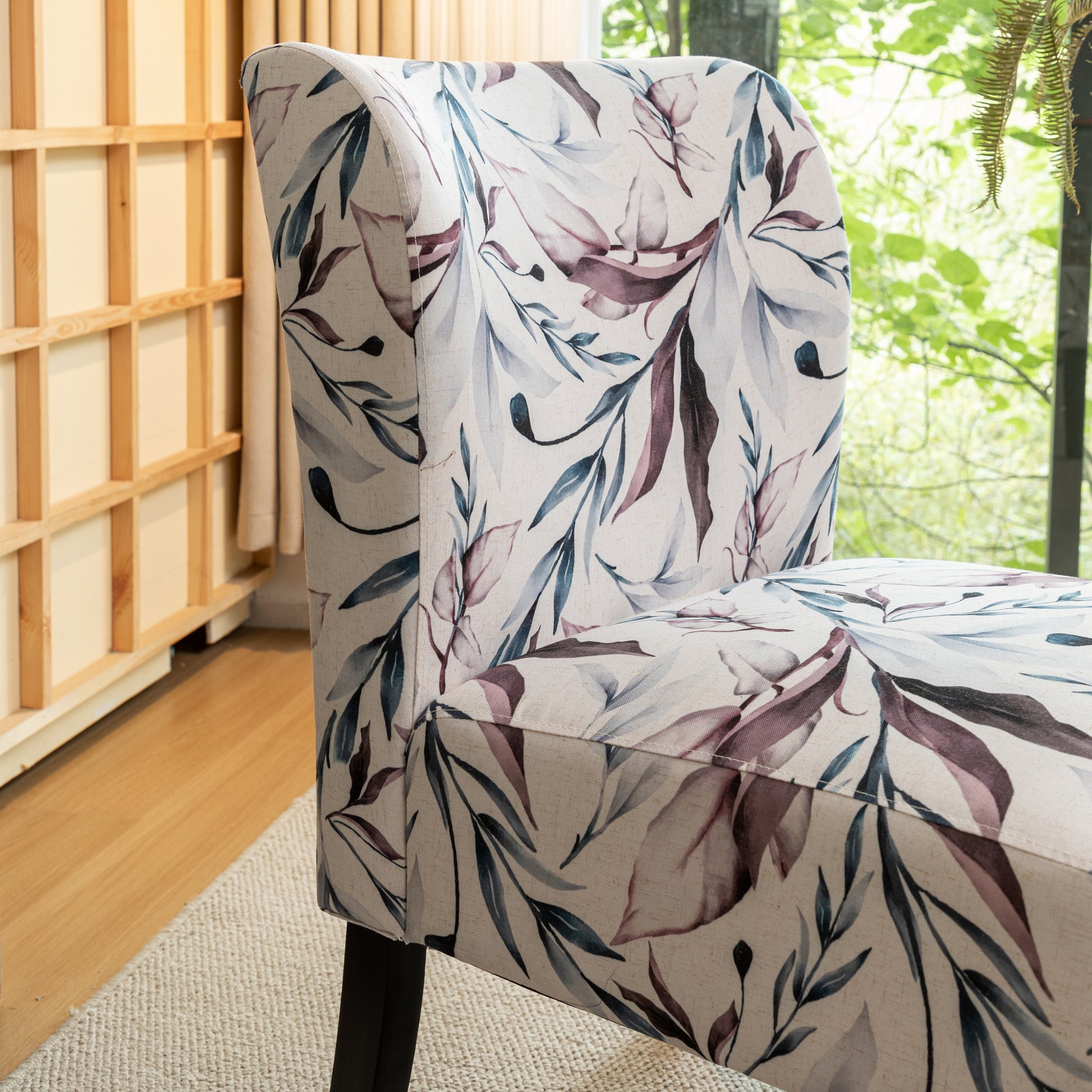 Upholstered armchair with a delicate floral leaf pattern in blues and purples on a cream background