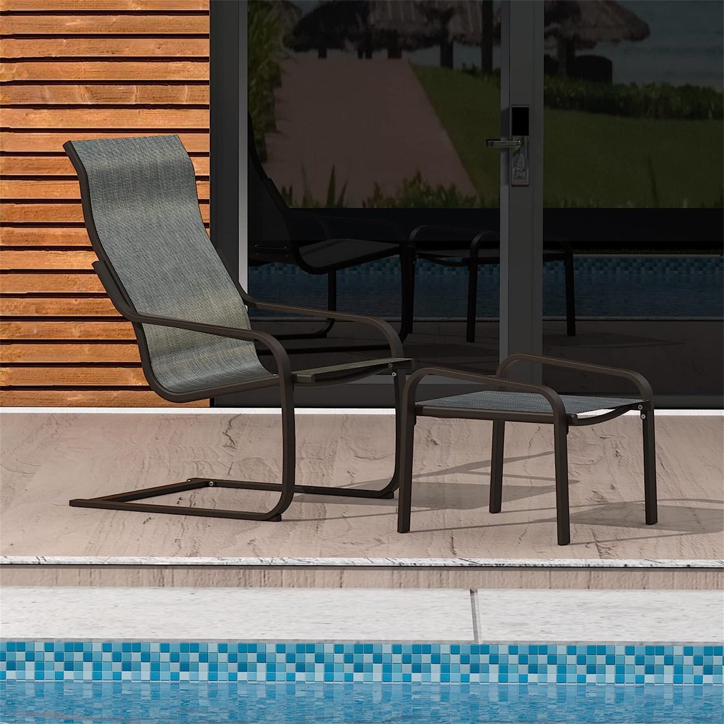 Gray sling lounge chair with dark metal frame and matching ottoman by pool