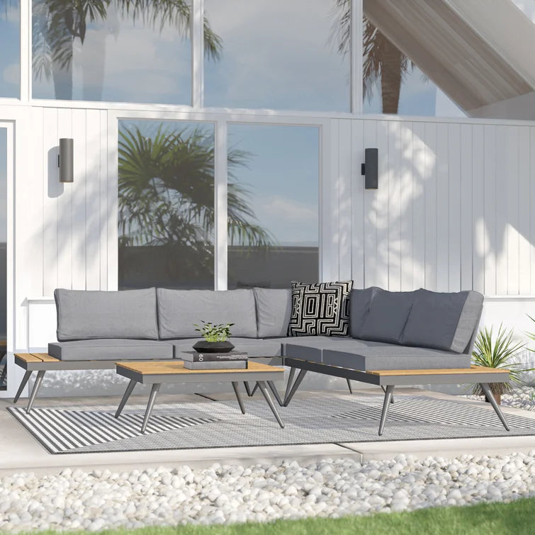 Modern grey sectional outdoor sofa with wooden accents and black patterned pillow