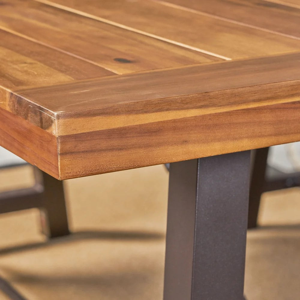 Close up of a rustic wood tabletop with a dark metal leg perfect for outdoor patio dining