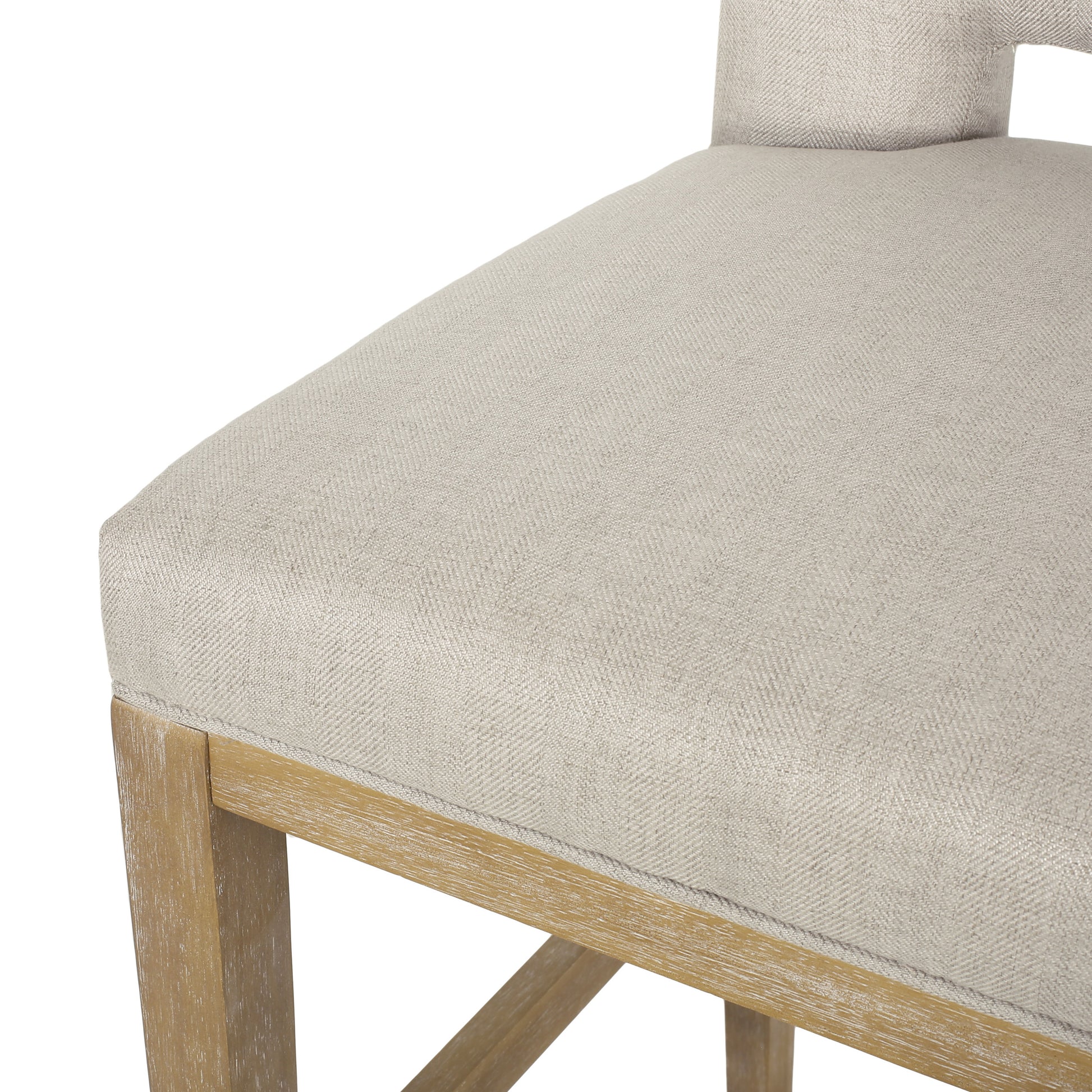 Close up of a neutral woven fabric seat cushion on a light wood frame counter stool