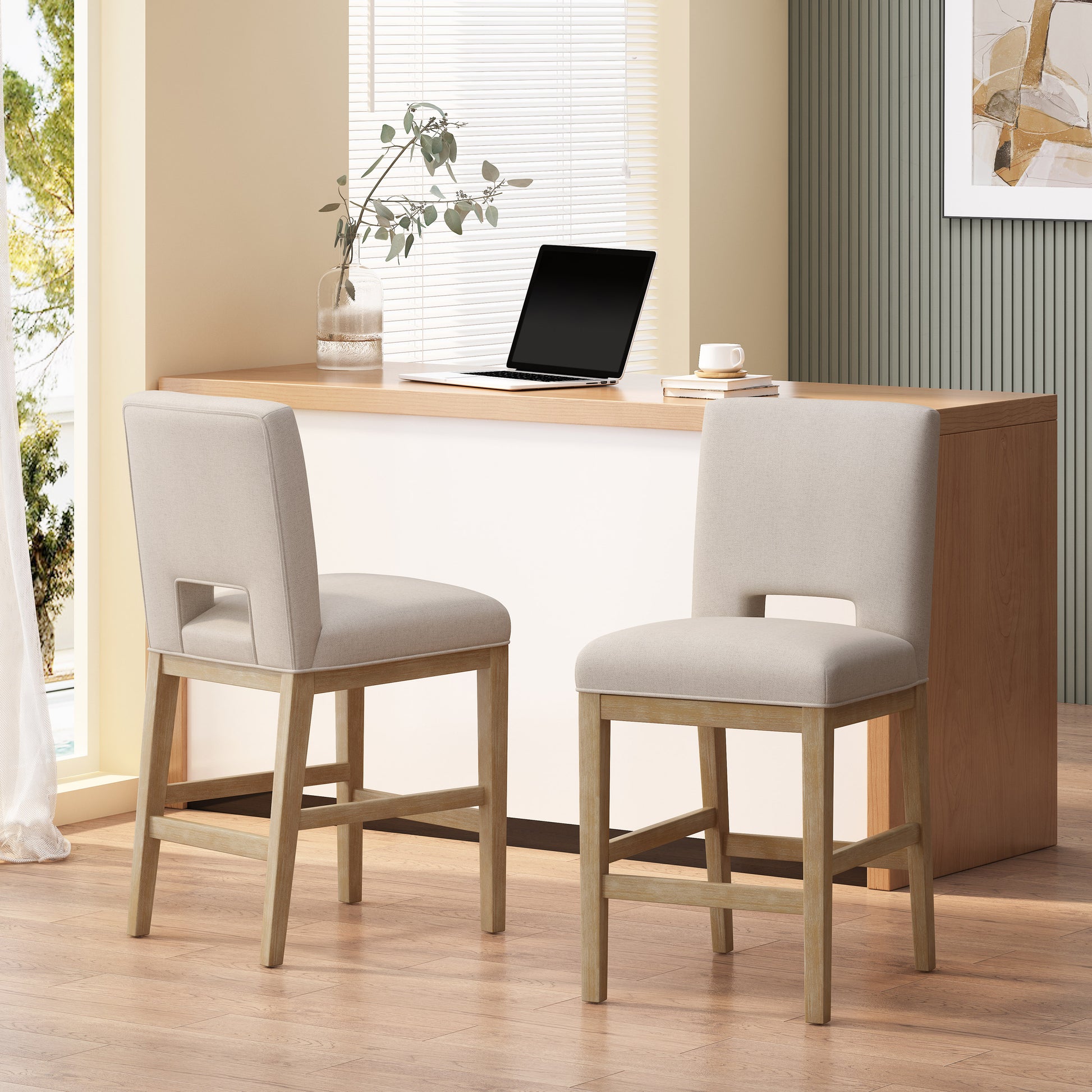 Two neutral beige upholstered counter stools with light wood frames perfect for a modern kitchen island