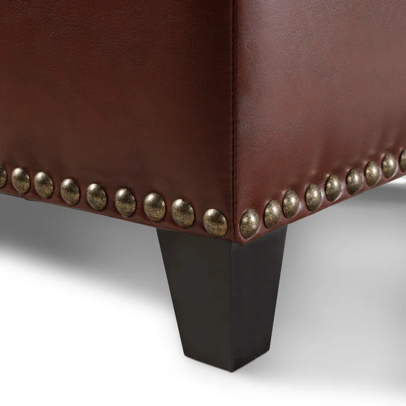 Brown leather ottoman corner detail with antique brass nailhead trim