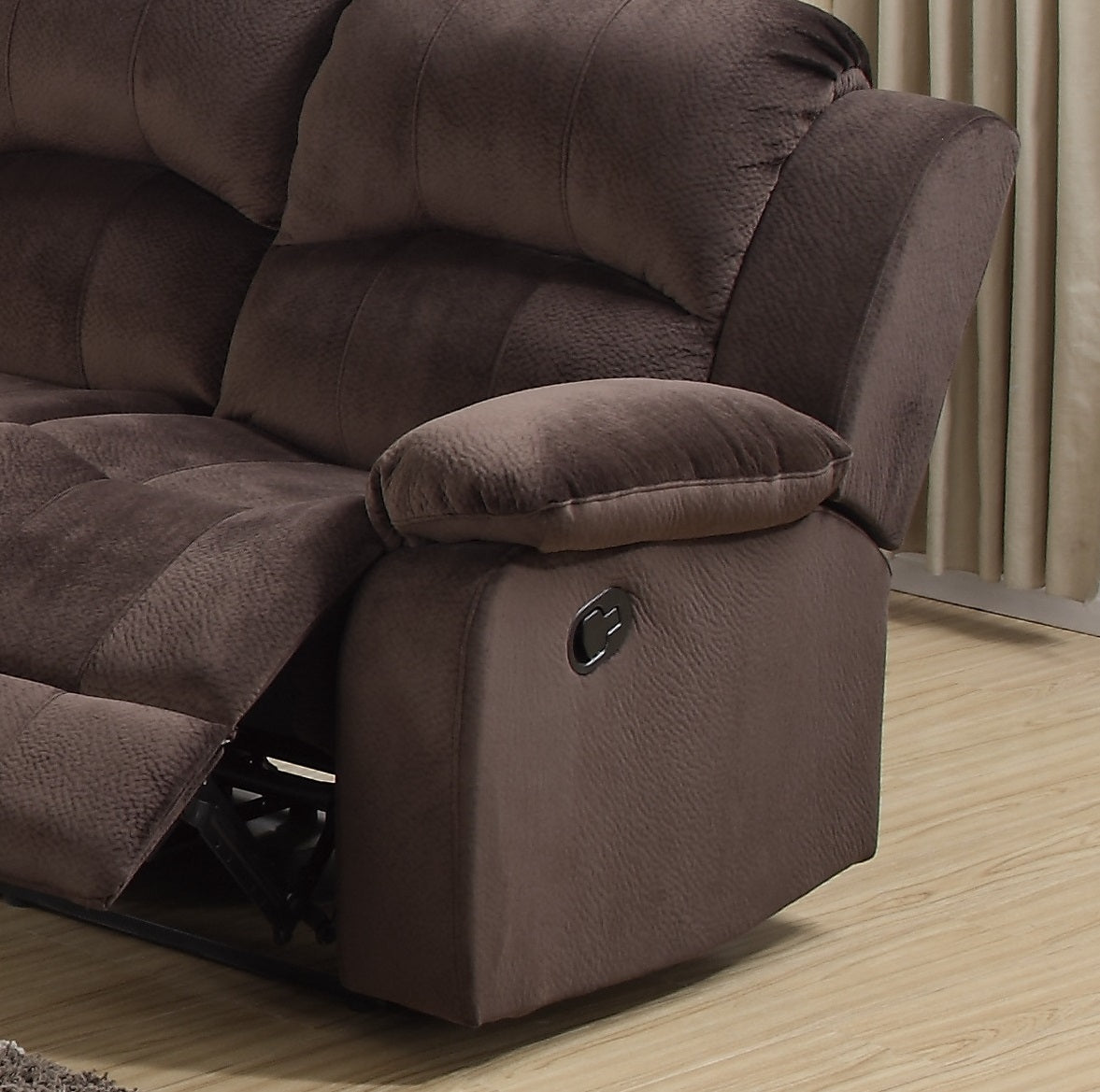 Brown plush reclining sofa with padded armrest and manual lever