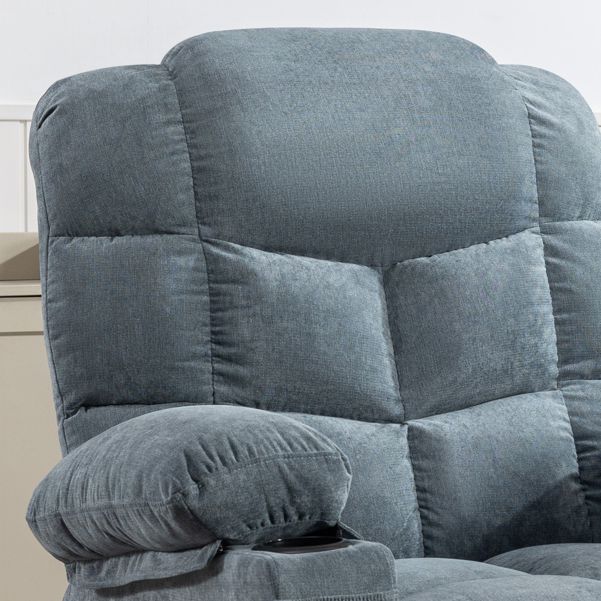 Plush grey recliner chair with quilted backrest and padded armrest for ultimate comfort