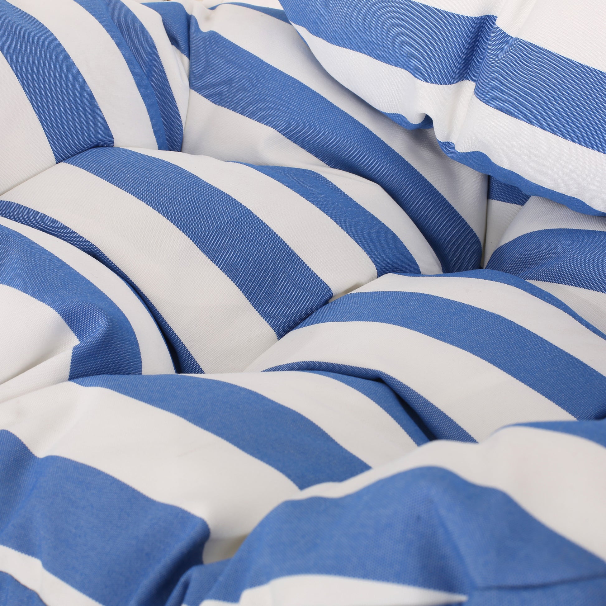 Closeup of plush outdoor cushion with classic blue and white stripes for patio furniture