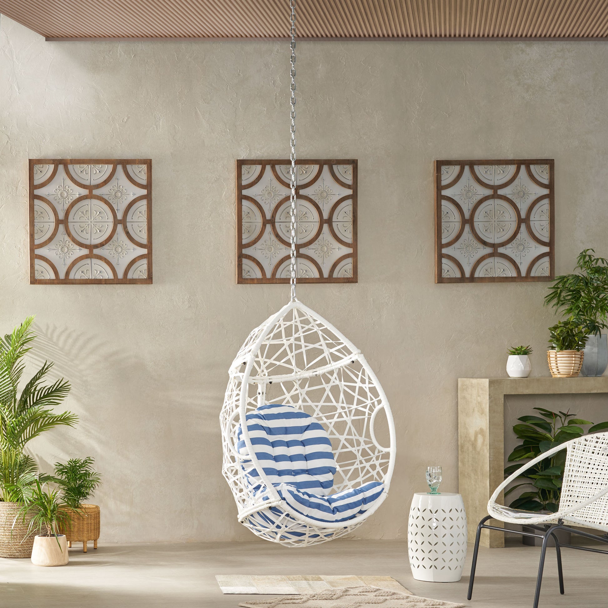White wicker egg chair with blue striped cushion perfect for outdoor relaxation