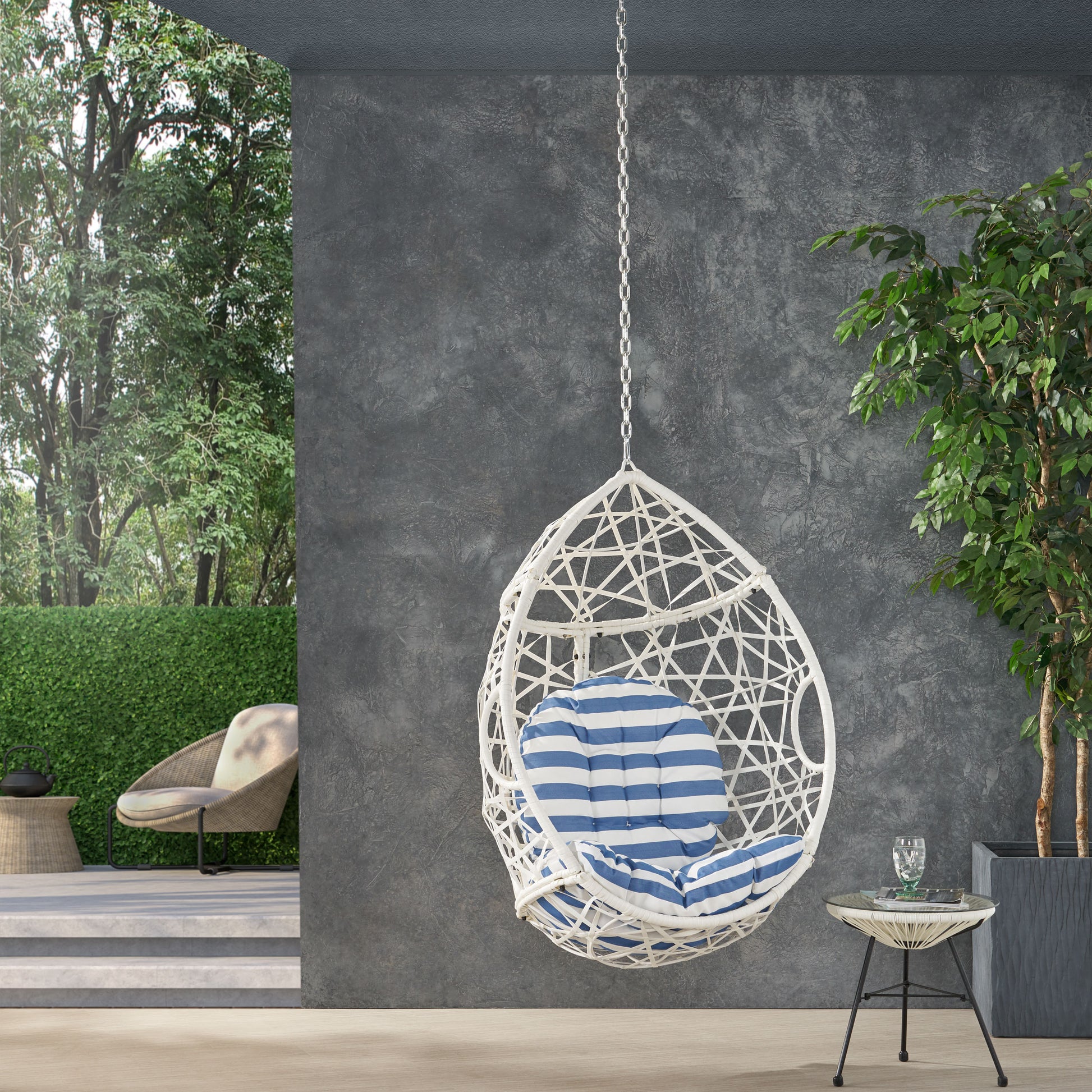 White woven egg chair with blue and white striped cushion perfect for patio relaxation