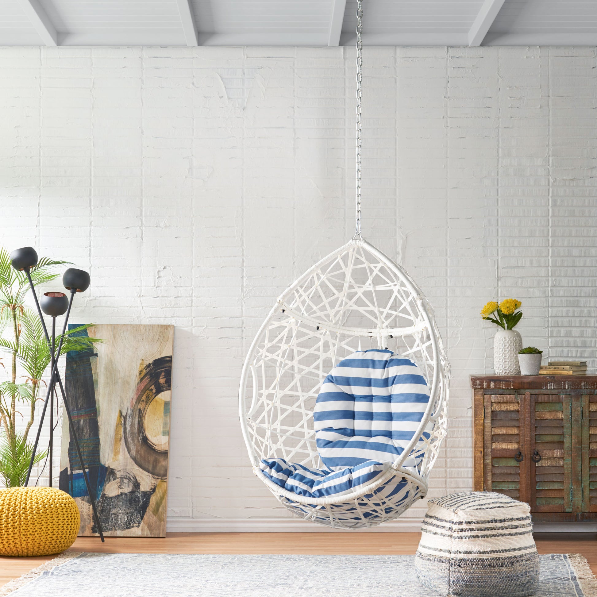 White woven egg chair with blue and white striped cushion for cozy indoor seating