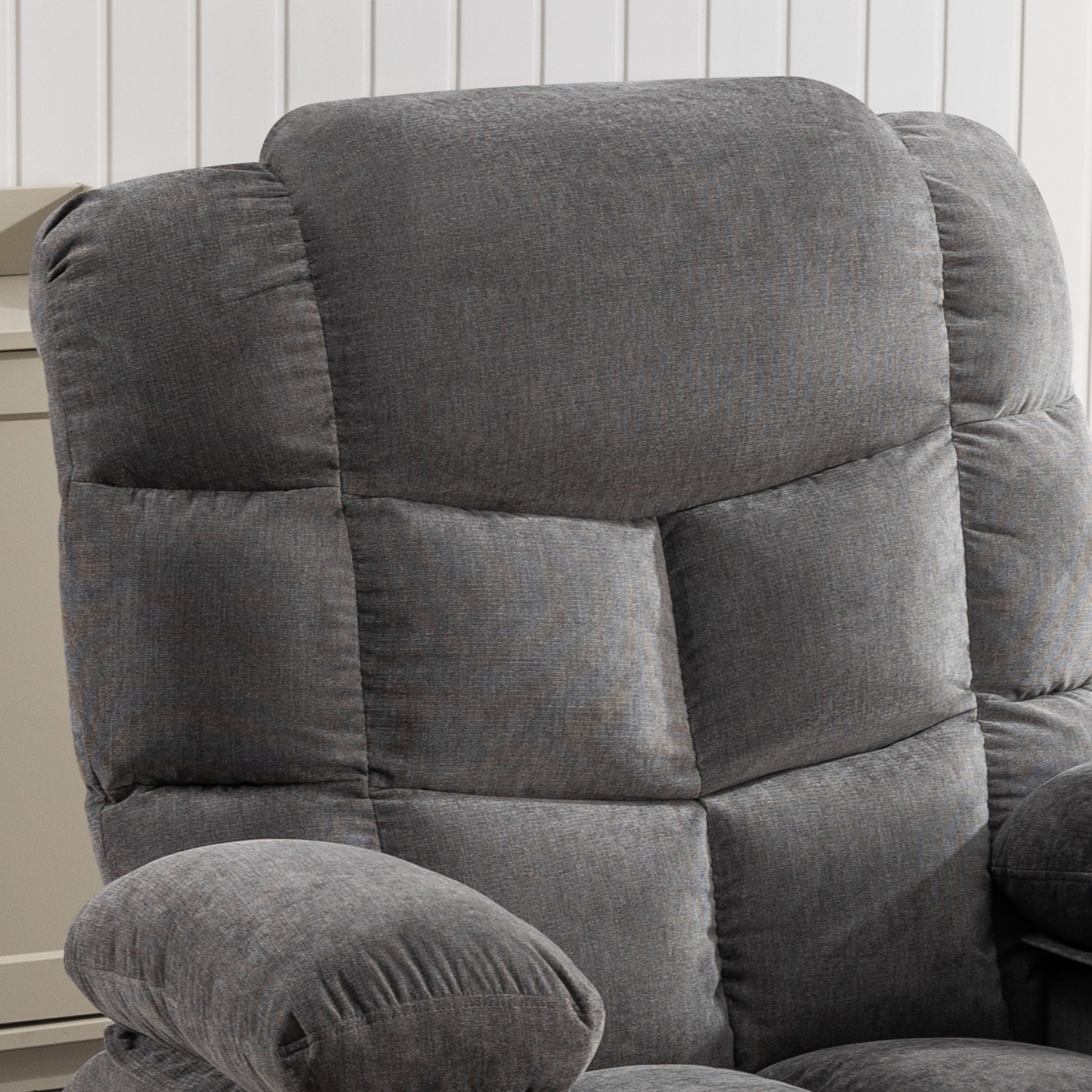 Closeup of a plush gray fabric recliner with deep cushioning and detailed stitching