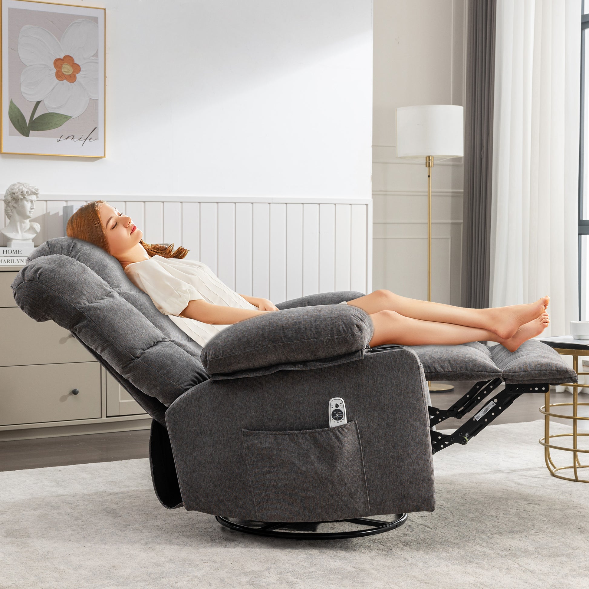 Dark grey fabric recliner chair with plush cushioning and a builtin side pocket holding a remote control